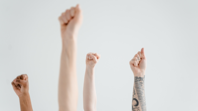 grey background with fist pointing to the sky